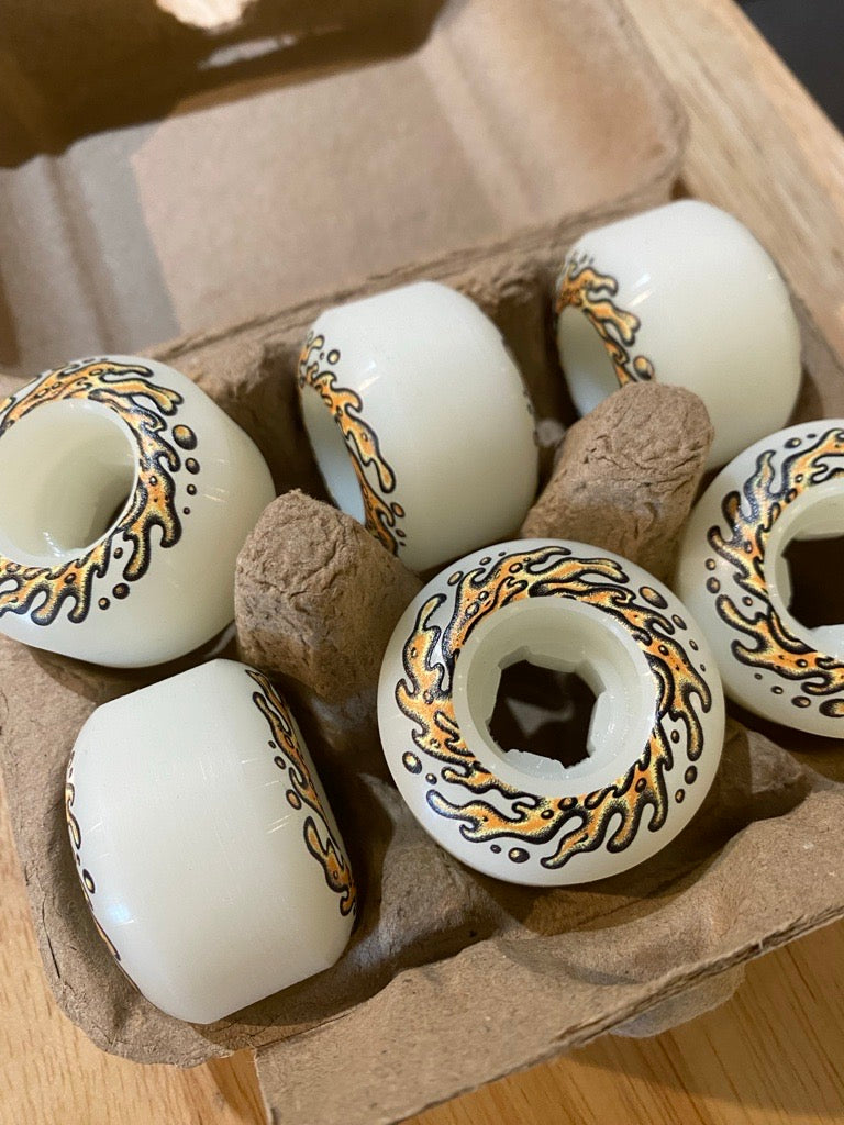 Decorative eggs with intricate designs in a cardboard carton on a wooden surface