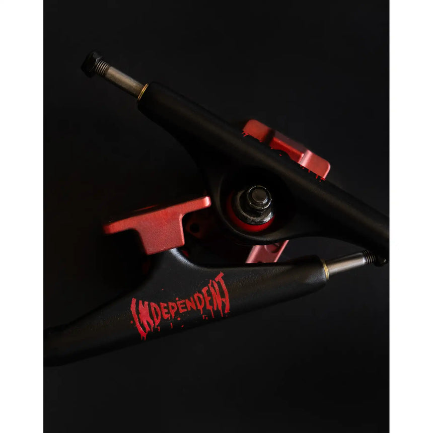 Black and red Independent skateboard truck on a black background