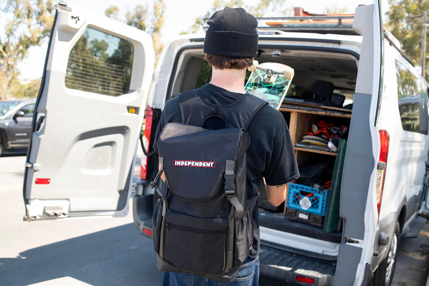 Person with a backpack labeled 'Independent' standing next to an open van.