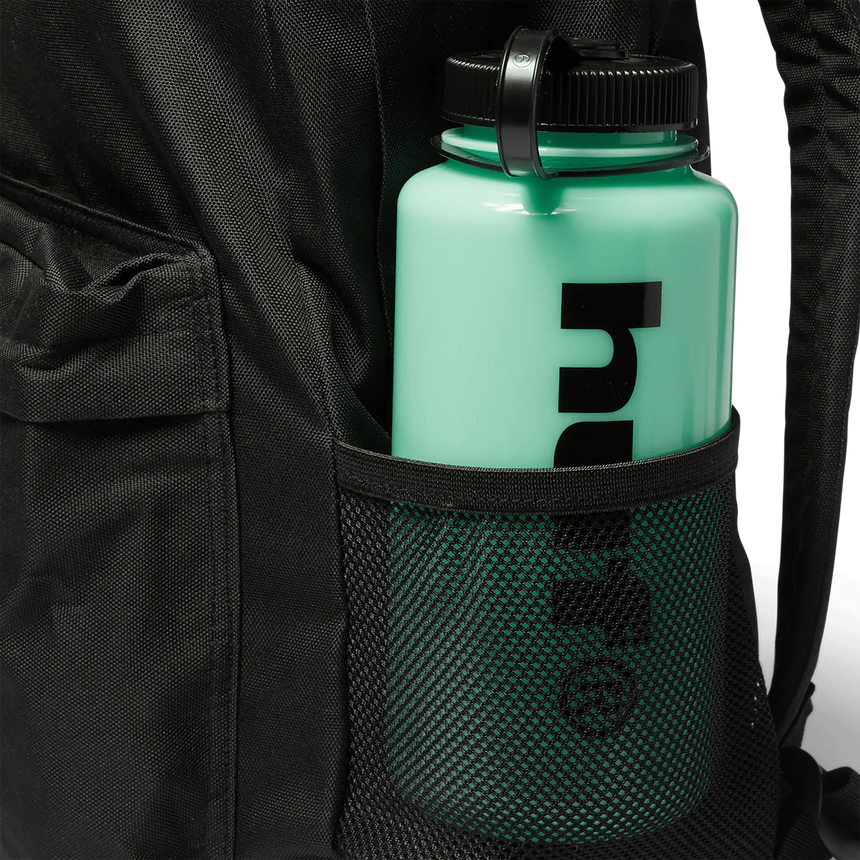 Green water bottle with black lid held in a black backpack pocket