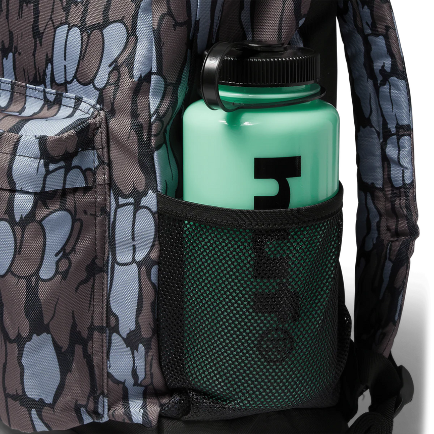 Green water bottle with black cap in a pocket of camouflage-patterned clothing