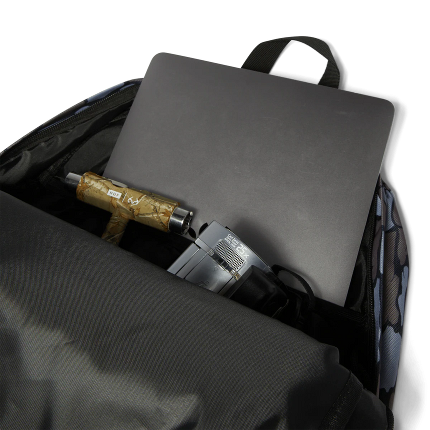 Backpack with laptop, umbrella, and other items on a white background