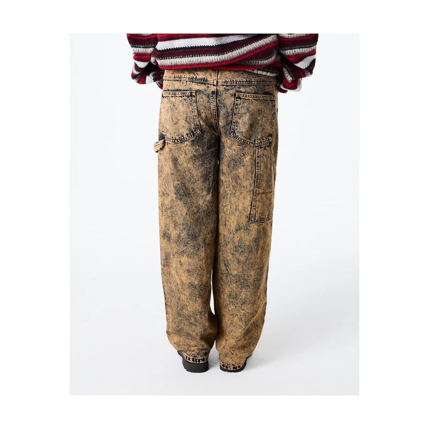 Distressed brown jeans worn with a striped sweater on a white background