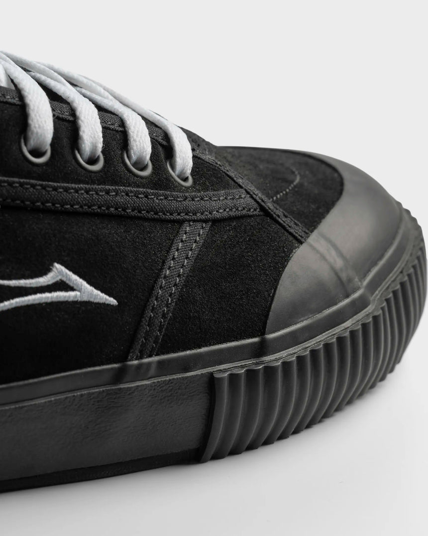 Black sneaker with a brand logo on a light gray background