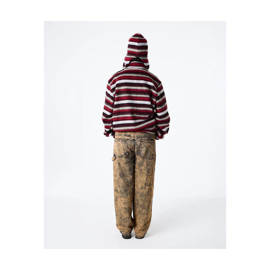 Person wearing a striped hoodie and dirty pants on a white background