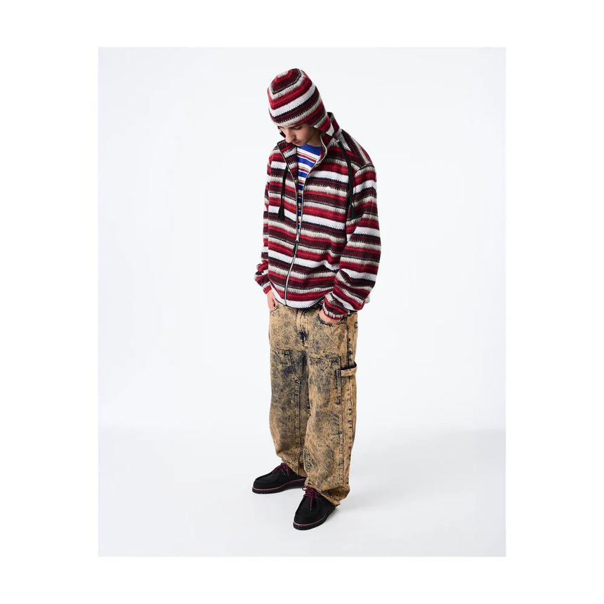 Person wearing a striped hoodie and pants on a white background
