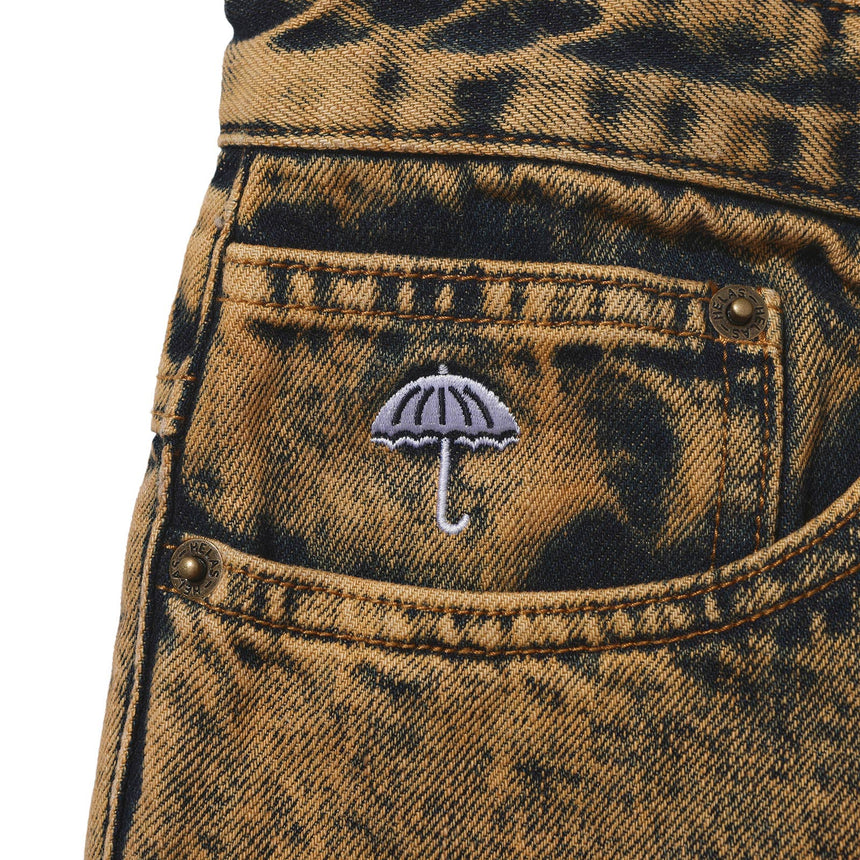 Close-up of a pocket with an embroidered umbrella design on a distressed denim background.