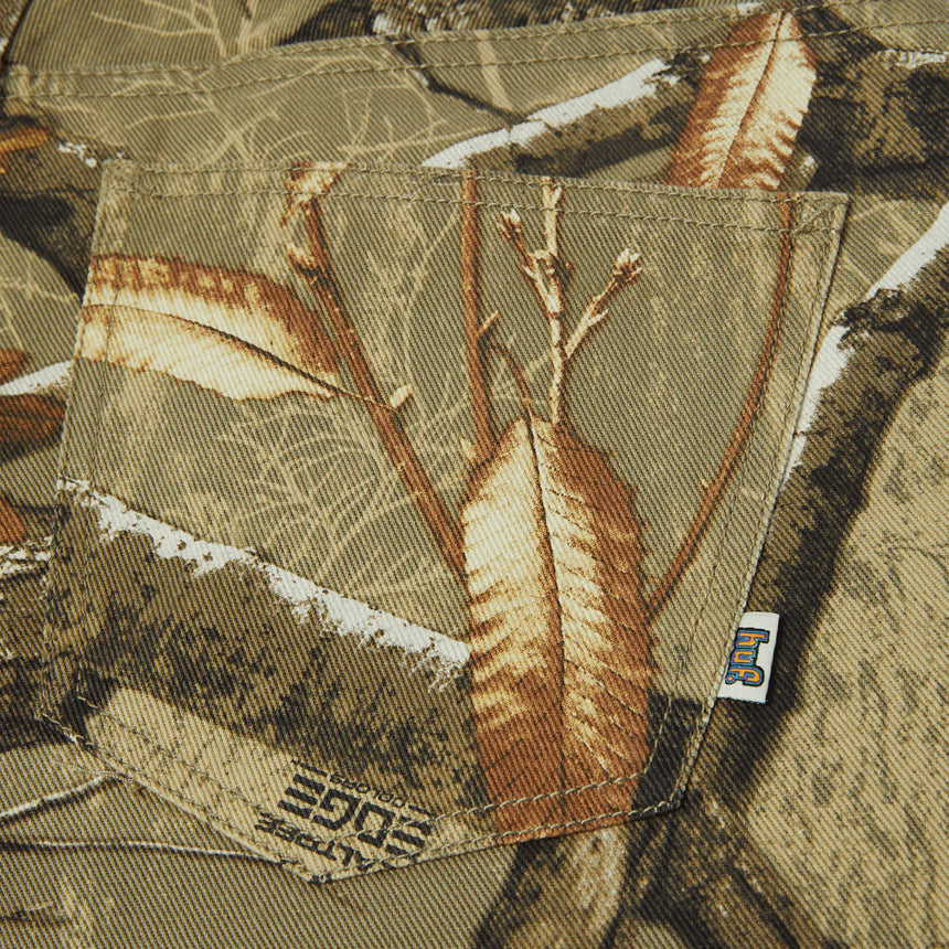 Camouflage-patterned fabric with a visible brand label on a close-up of clothing.