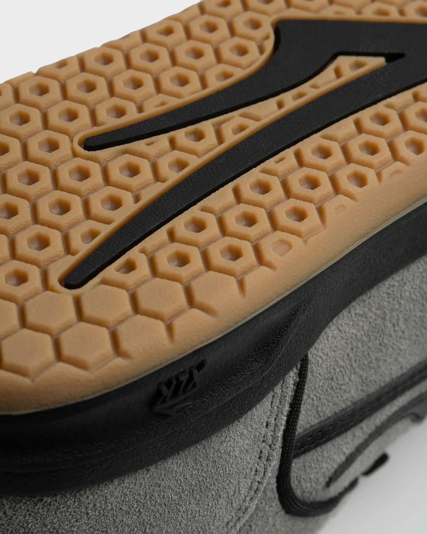 Close-up of a textured shoe sole with a brand logo on a white background
