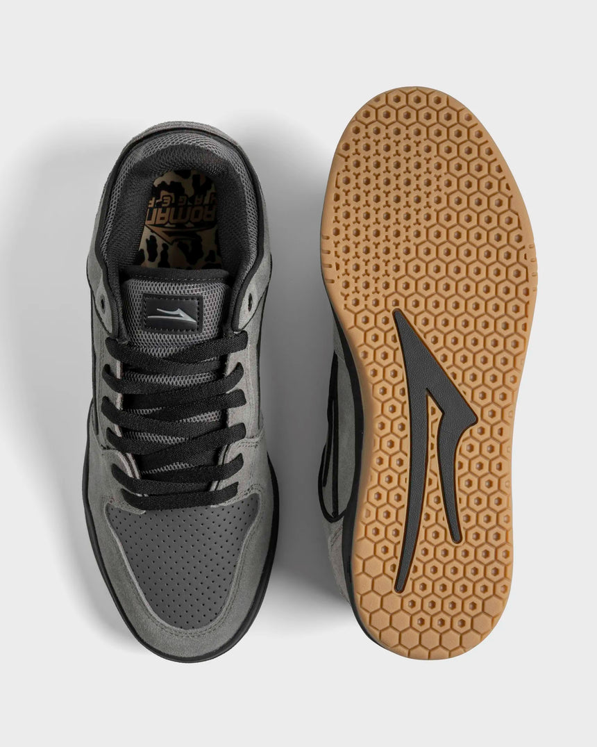 Gray sneaker with black laces and a patterned sole on a light gray background