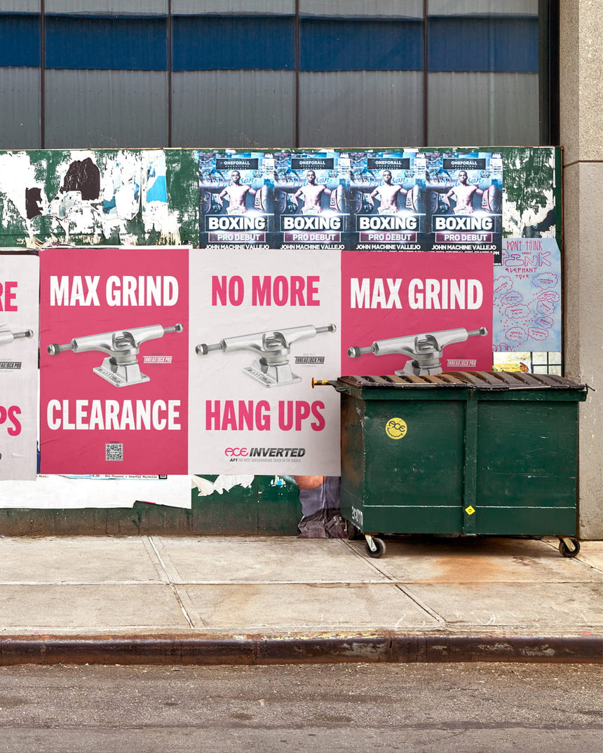 Outdoor advertising posters on a wall next to a dumpster