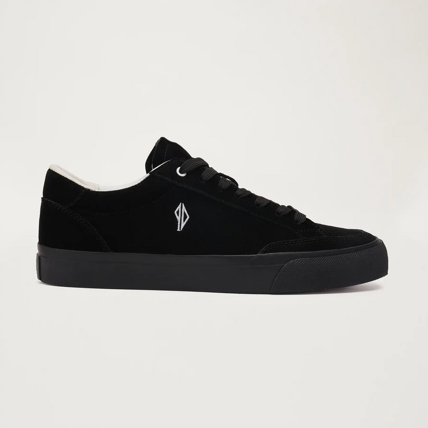 Black sneaker with a small logo on a light gray background