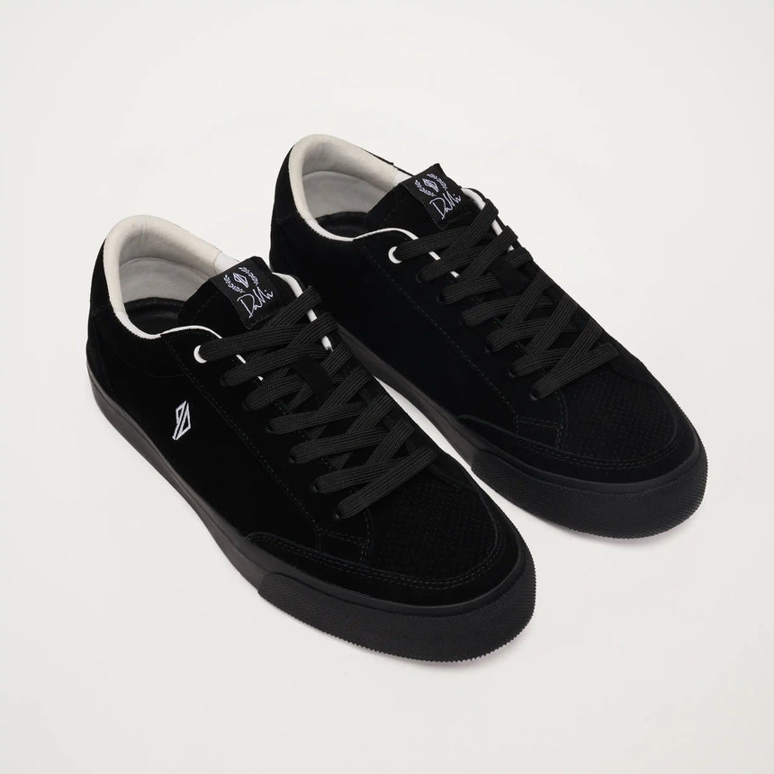 Black sneakers with white soles on a light gray background