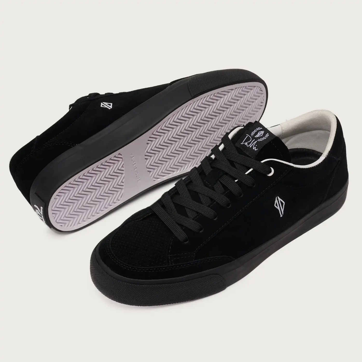 Black sneakers with white soles on a light gray background