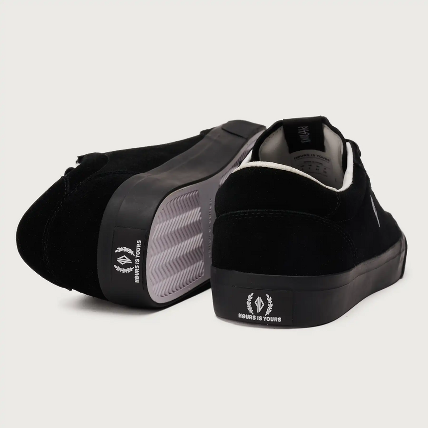 Black sneakers with white logo on a light gray background