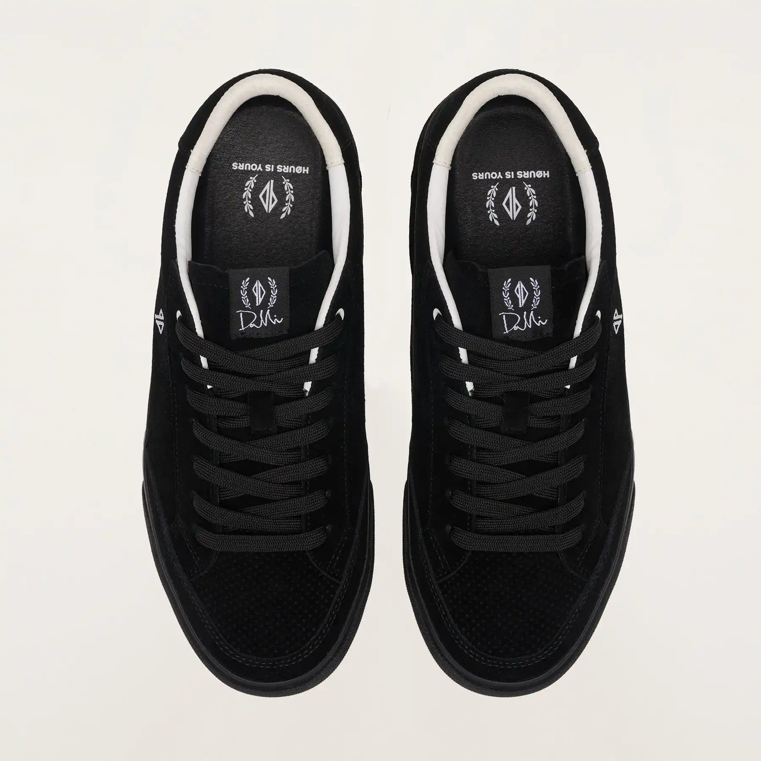 Black sneakers with white soles on a light gray background