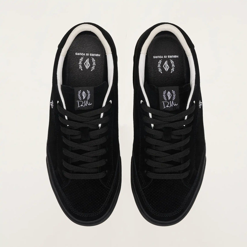 Black sneakers with white soles on a light gray background