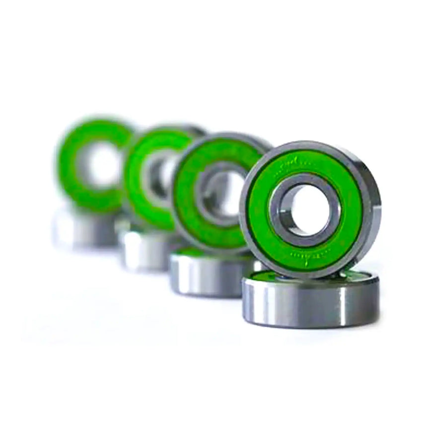 Row of metallic bearings with green inner races on a white background