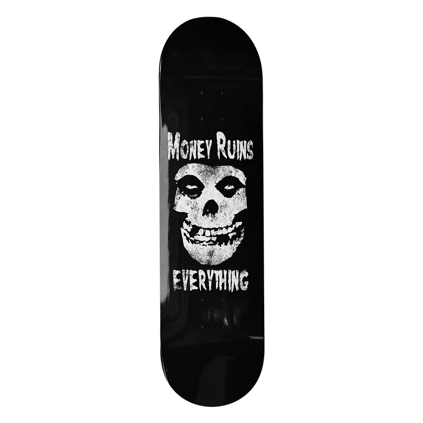 Skateboard deck with skull design and text 'Money Ruins Everything' on a black background