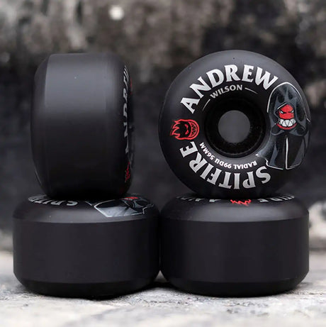 Black skateboard wheels with branding on a textured surface
