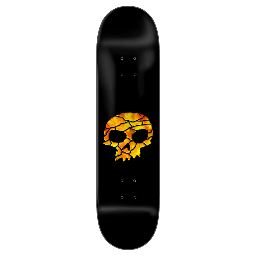 Black skateboard deck with a skull design in orange and yellow on a white background