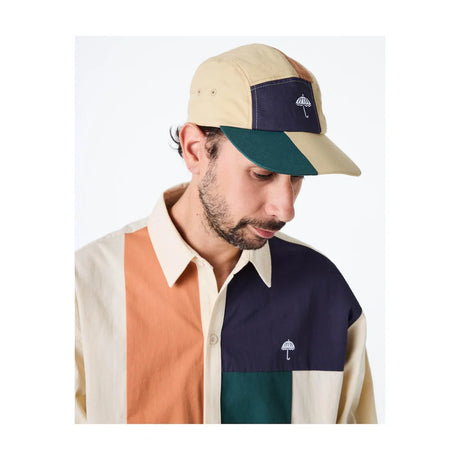 Man wearing a color-blocked cap and shirt with a visible brand logo.