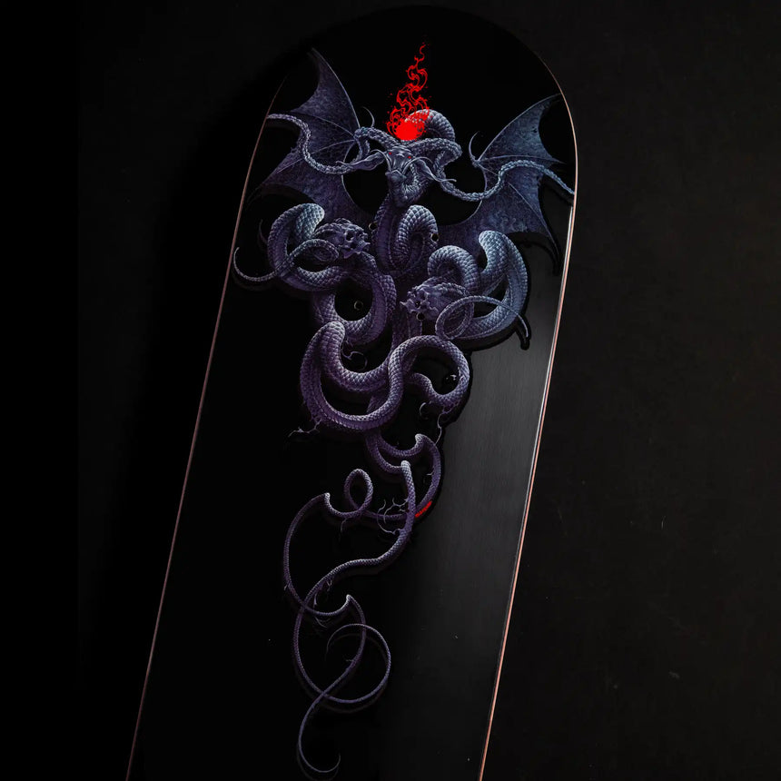 Skateboard deck with a detailed dragon design on a black background