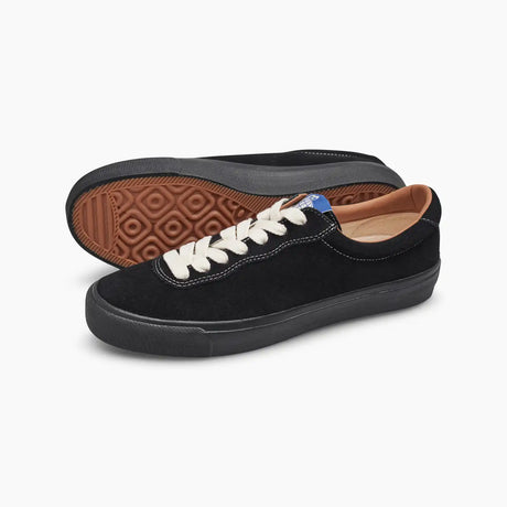 Black sneakers with white laces on a light gray background