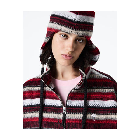Person wearing a red and white striped knit hat and jacket on a white background