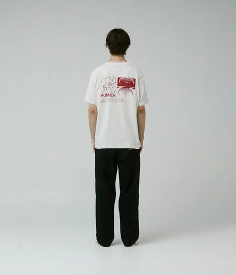Person wearing a white t-shirt with a graphic design on the back, standing against a plain background