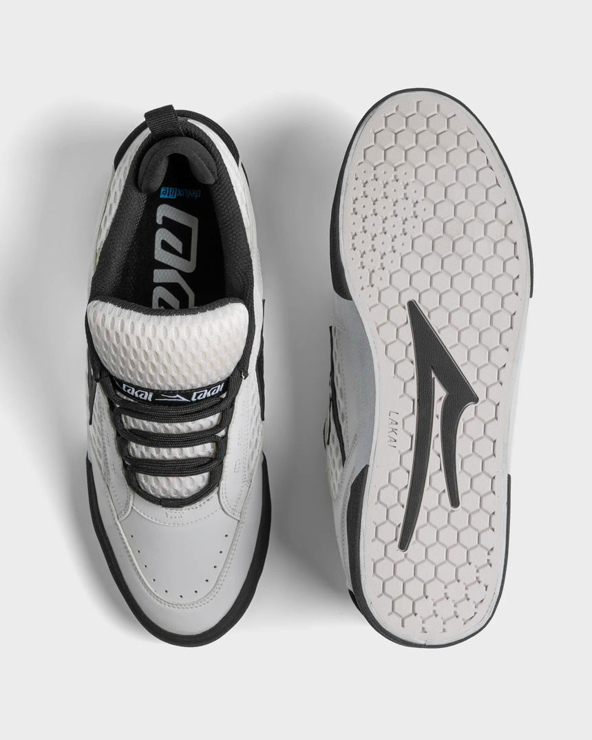 White and black sneaker with visible brand logo on a light gray background