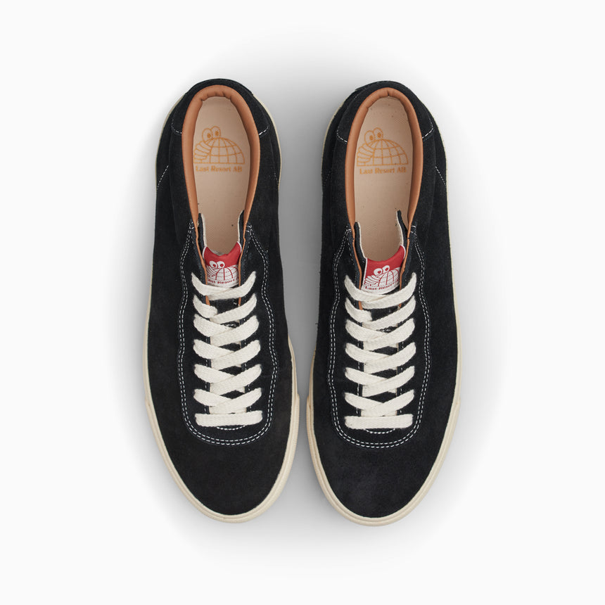 Pair of black sneakers with white laces on a white background