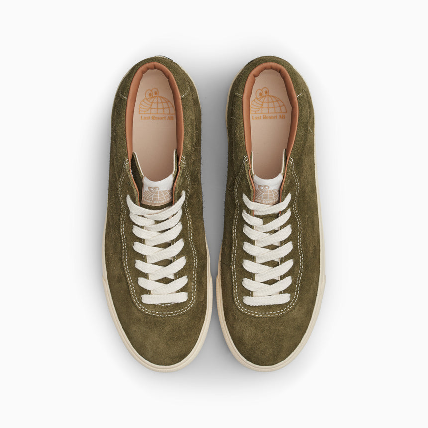 Pair of green sneakers with white laces on a white background