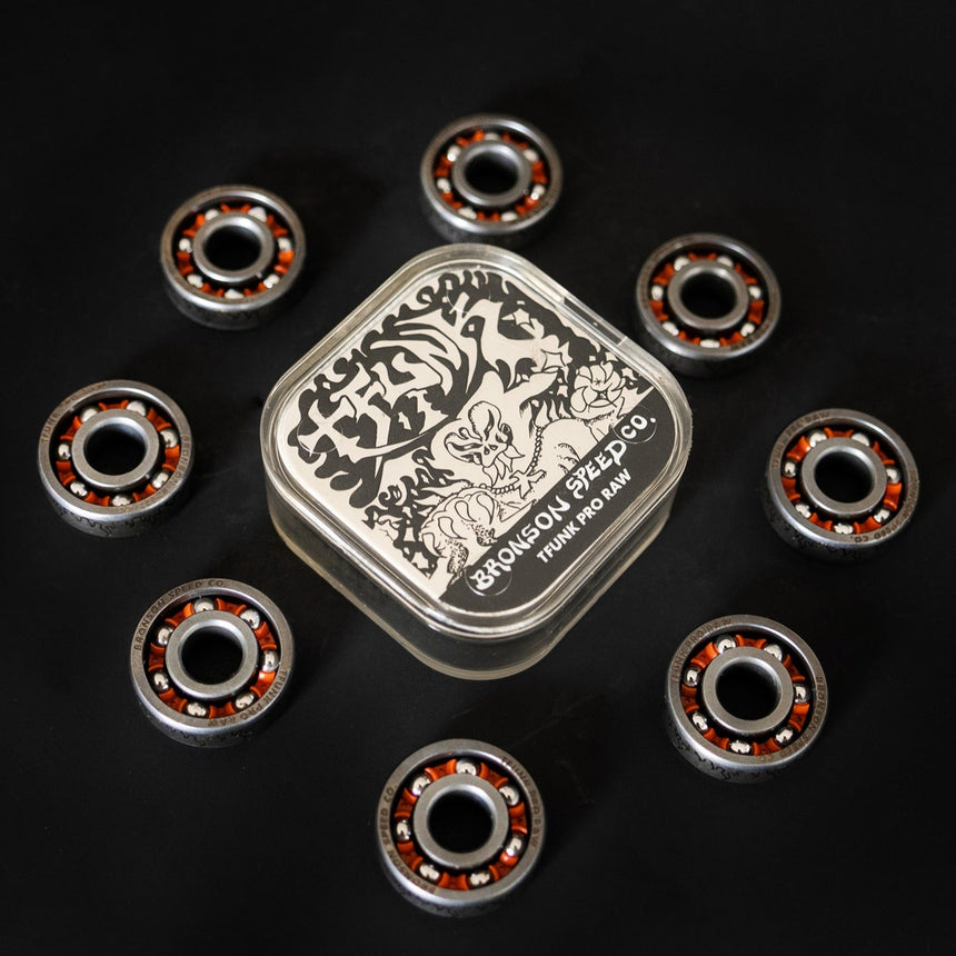 Collection of bearings with a branded container on a black background