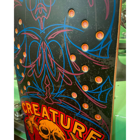 Skateboard deck with colorful creature design and 'Creature' branding.