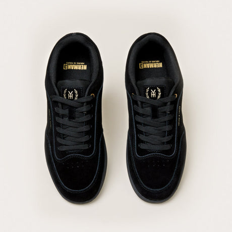 Black sneakers with gold accents on a white background