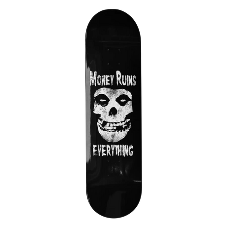 Skateboard deck with skull design and text 'Money Ruins Everything' on a black background