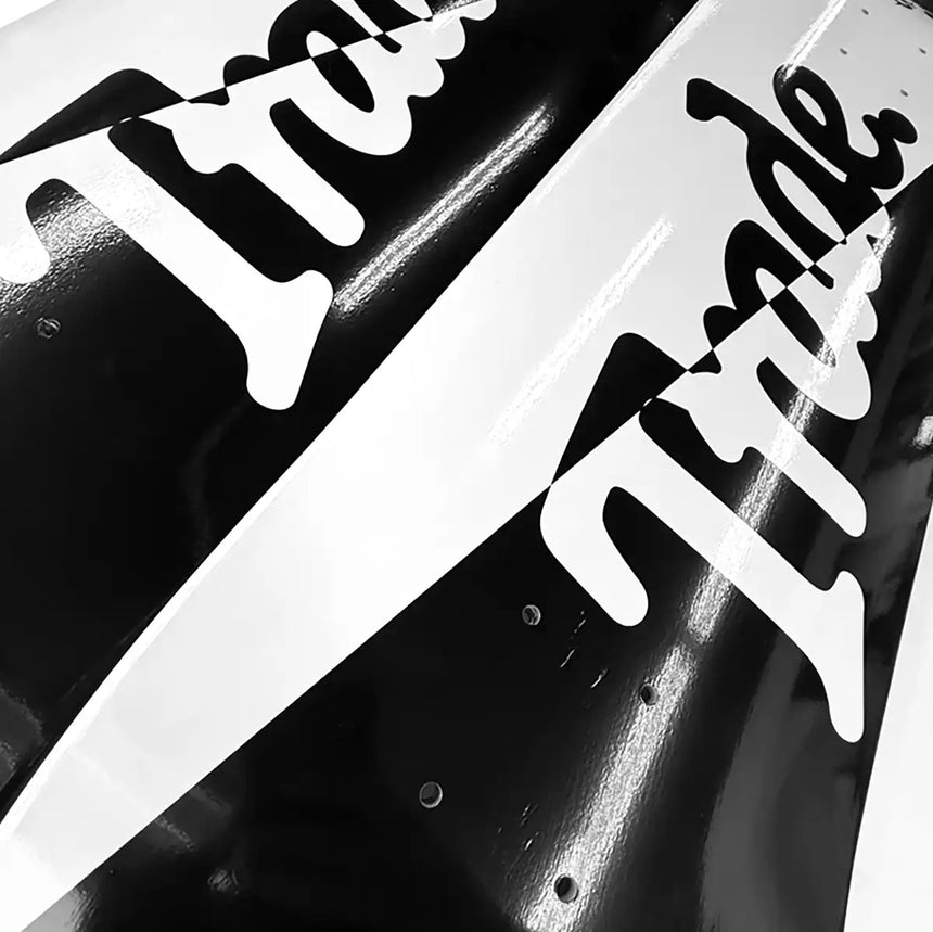 Close-up of a black and white 'Tide' logo on a product packaging.