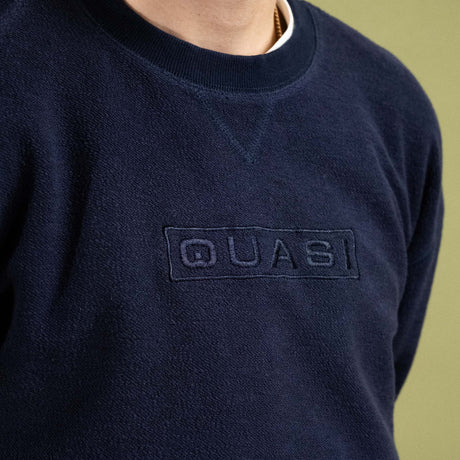 Navy blue sweatshirt with 'QUASI' logo on a plain background