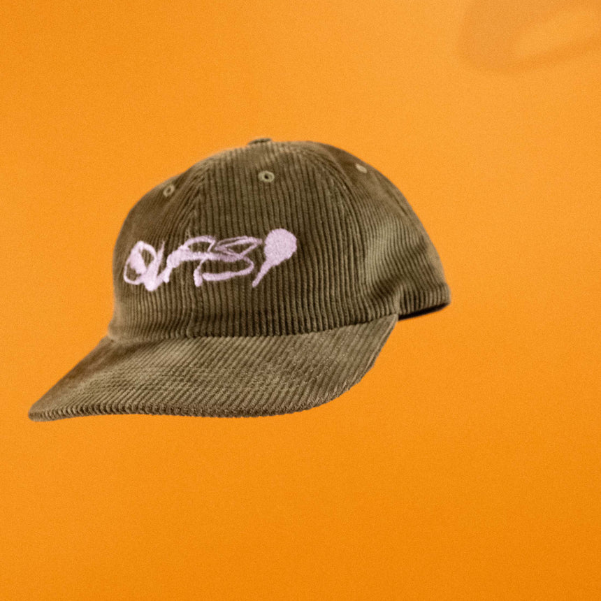 Green cap with a logo on an orange background