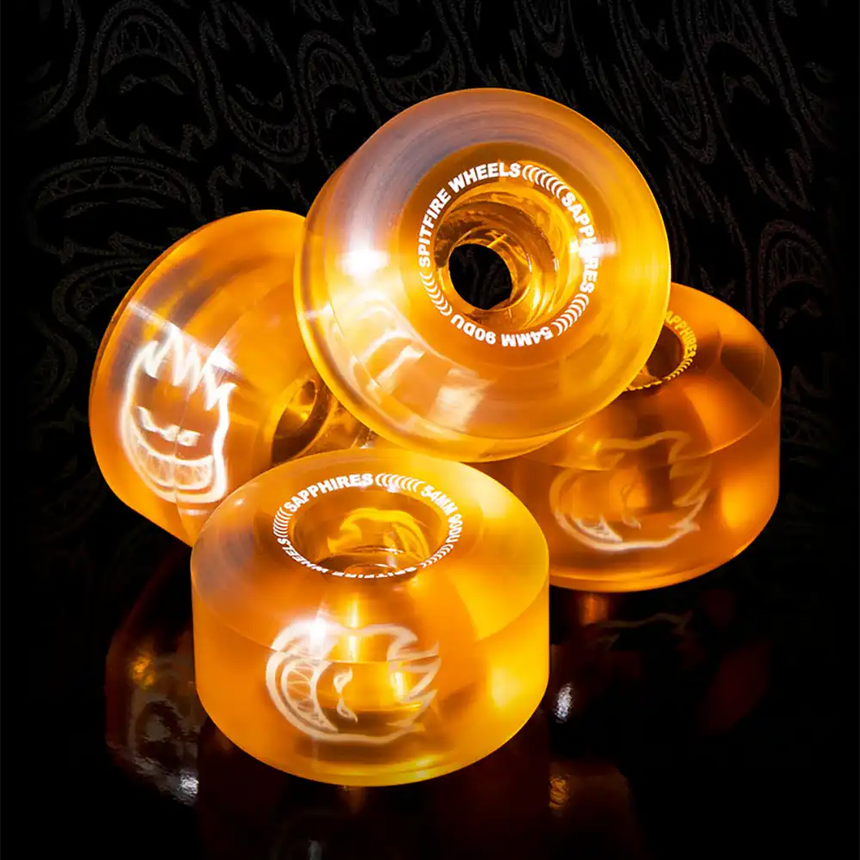 Orange skateboard wheels with visible brand name on a dark background