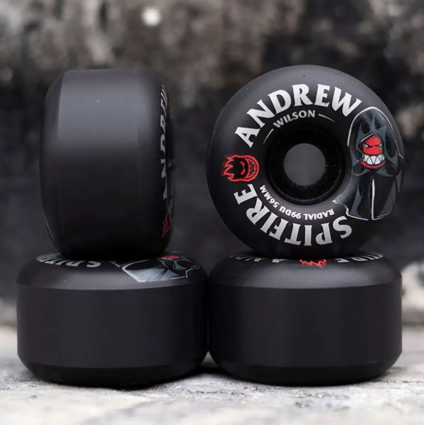 Black skateboard wheels with branding on a textured surface